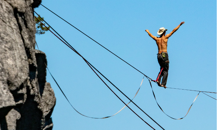 Photographie d'un homme en équilibre sur un fil