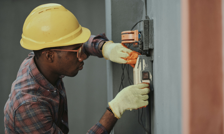 Photographie d'un homme travaillant sur un compteur électrique