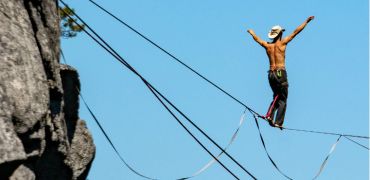 Photographie d'un homme en équilibre sur un fil