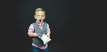 Photographie d'un jeune garçon avec un livre dans la main