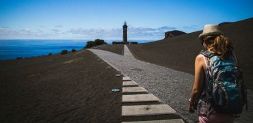Photographie d'une femme avancat sur un chemin en bord de mer
