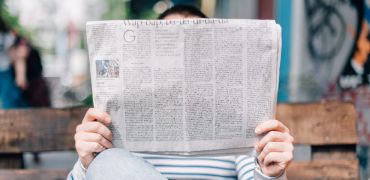 Photographie d'un homme lisant un journal