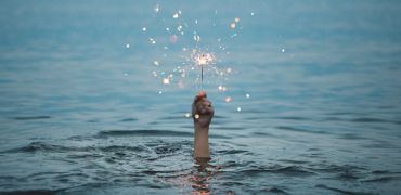 Photographie d'une main au dessus de l'eau