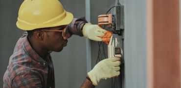 Photographie d'un homme travaillant sur un compteur électrique
